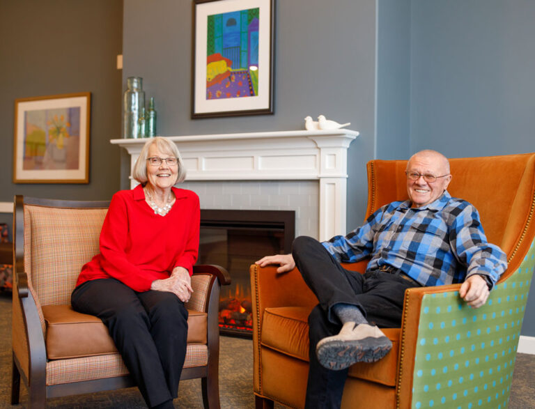 Couple happily sitting together in a gathering space.